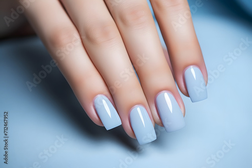 Glamour woman hand with baby blue nail polish on her fingernails. Blue nail manicure with gel polish at luxury beauty salon. Nail art and design. Female hand model. French manicure.