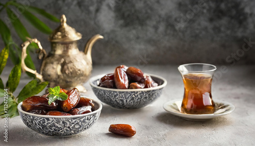 Dates in ornate bowls, a vintage teapot, and a glass of tea, capturing the essence of Ramadan.