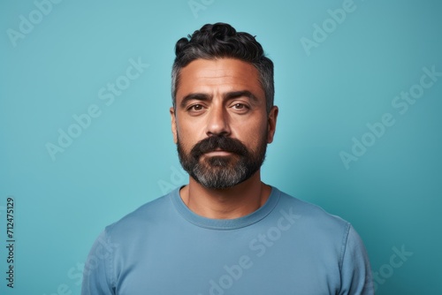 Portrait of handsome bearded man in blue t-shirt on blue background