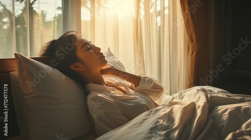 Simple lifestyle, Asian woman wakes up from good sleep on weekend morning, takes some rest, relax in comfortable bedroom at hotel window, happy lazy day, comfortable, dreaming photo