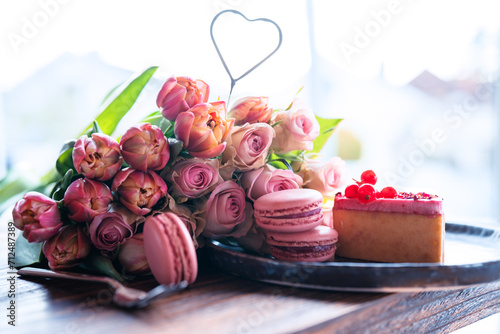 Beautiful pink roses and tulips with sweet pastrys. Concept background for mother's day, valentine's day and weddings. Close-up with short depth of field. photo