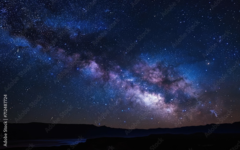 The night sky is filled with numerous twinkling stars and fluffy clouds, creating a beautiful celestial scene.