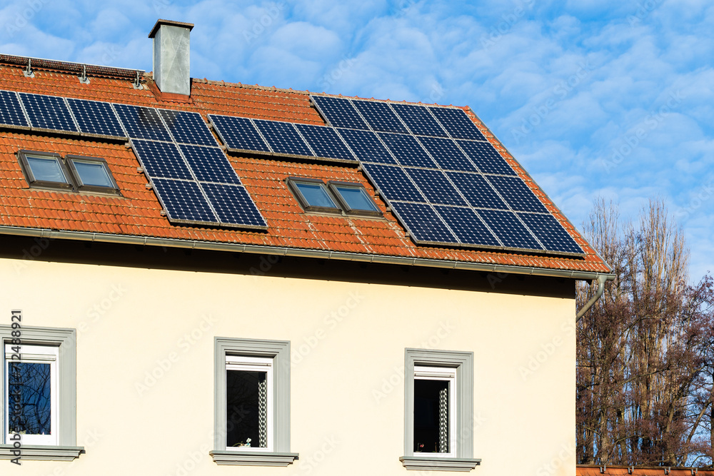 Fototapeta premium Ziegeldach mit Photovoltaikanlage und Dachflächenfenstern