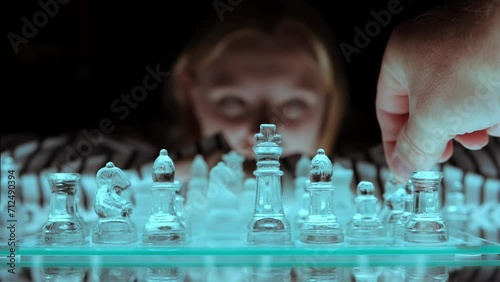 evening game of chess close-up on glass chess in the evening, the girl is supposed to sit and think photo