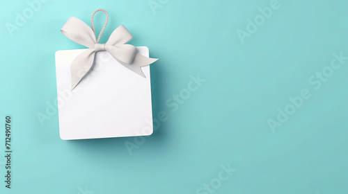 Card, gift and paper sign with bow on blue background for copy space announcement, invitation message or offer. Bow, ribbon, white coupon for discount, sale, special surprise voucher.