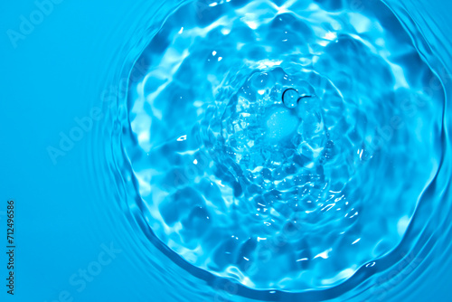 The water surface is clear blue with circular waves.