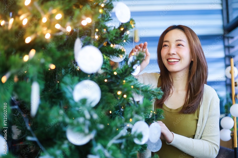 woman decorating christmas tree woman decorating christmas tree