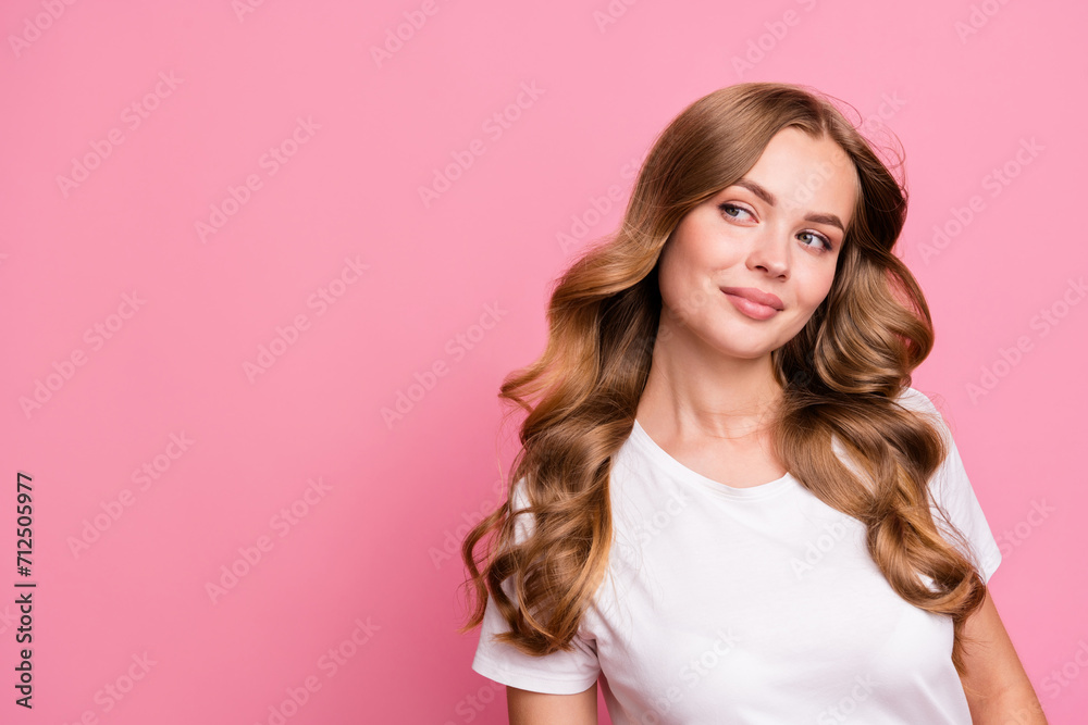 Portrait of nice girl with fluttering curly hairdo dressed white t-shirt look at discount empty space isolated on pink color background Portrait of nice girl with fluttering curly hairdo dressed white t-shirt look at discount empty space isolated on pink color background