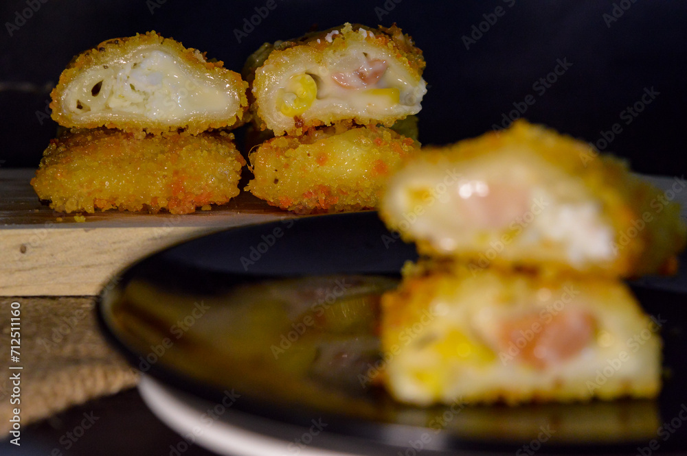 The Indonesian version of risoles or risoles is filled with mayonnaise, sausage, corn and boiled egg wrapped in a crepe-like wrapper and coated in breadcrumbs and deep-fried. selected focus. The Indonesian version of risoles or risoles is filled with mayonnaise, sausage, corn and boiled egg wrapped in a crepe-like wrapper and coated in breadcrumbs and deep-fried. selected focus.