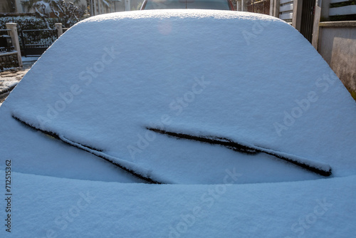 Foto Gros plan du pare-brise d'une voiture couverte d'une couche de neige dans la rue