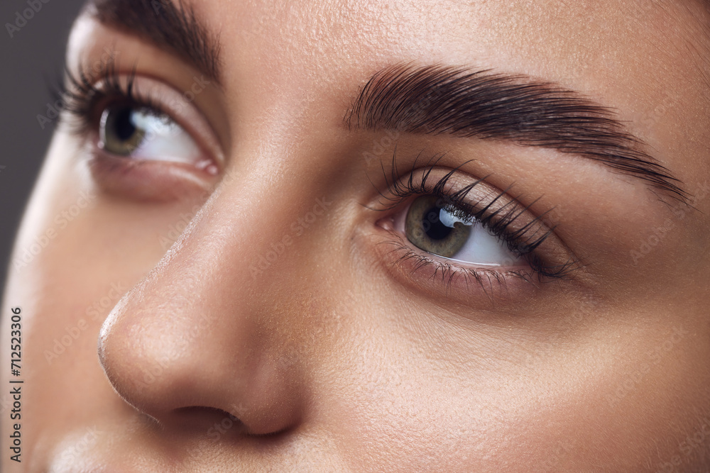 Close-up of a woman's eyes with well-defined eyebrows, long lashes, and smooth skin, highlighting meticulous grooming. Concept of mascara brand, lash volume and eye enhancement. Ad Close-up of a woman's eyes with well-defined eyebrows, long lashes, and smooth skin, highlighting meticulous grooming. Concept of mascara brand, lash volume and eye enhancement. Ad
