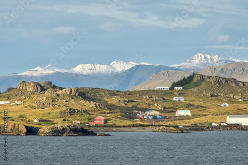 The small town of Djúpivogur, Iceland, backed by dramatic, snow capped peaks. photo