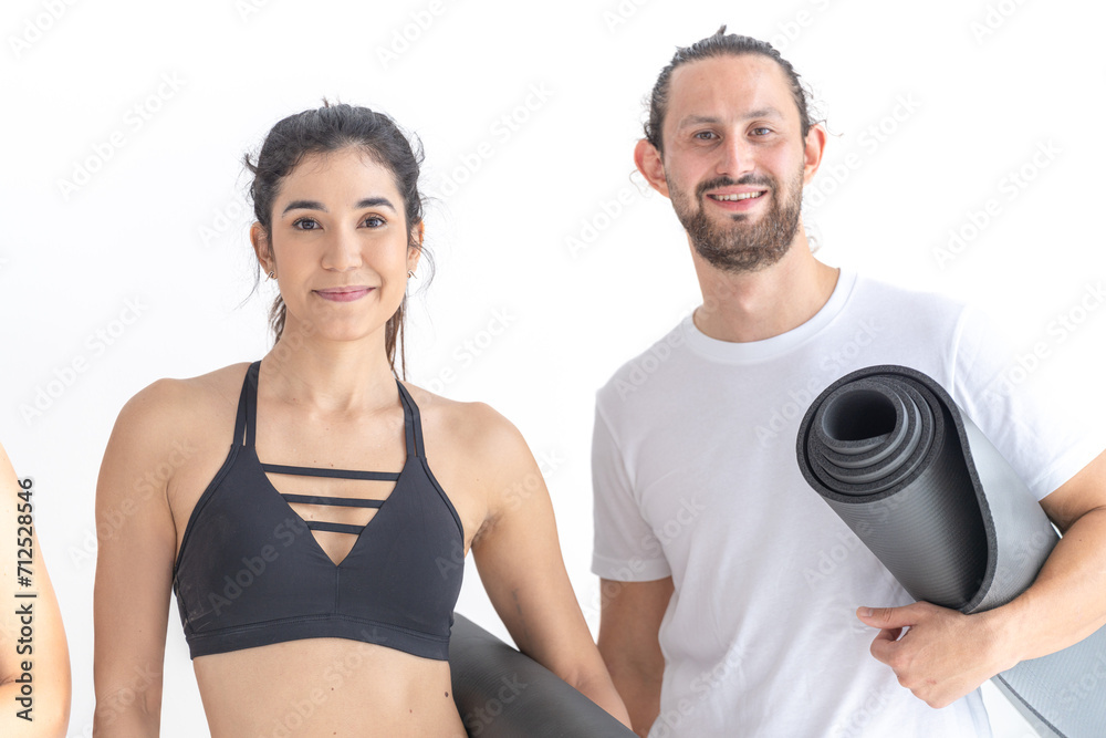 Group of happy sporty women and guy wearing body stylish sportswear holding personal carpets leaned on a white background. waiting for yoga class or body weight class. healthy lifestyle and wellness