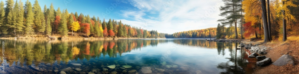 A panoramic view of a crystal-clear lake surrounded by vibrant autumn foliage