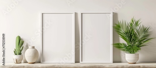 Two adjacent, empty, white frames on shelf, mock-up for photo. © AkuAku