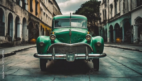 a green classic car sits on a brick road in an old european town