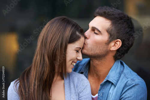 Love, kiss forehead and a happy couple outdoor for care, commitment and people in connection. Romance, man and woman together for bonding, smile in relationship and affection on valentines day date