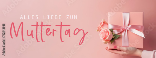 Alles Liebe zum Muttertag Feiertag Grußkarte mit deutschem Text - Mädchen hält Geschenkbox, Geschenk mit Rosen in ihren Händen, isoliert auf pinkem Hintergrund