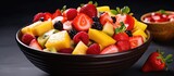 Healthy fruit salad with fresh pineapple, strawberries, and nutritious fruits in a plastic bowl.