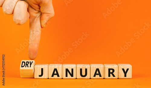 Dry January challenge symbol. Concept words Dry January on beautiful wooden cubes. Beautiful orange table orange background. Businessman hand. Dry January healthy lifestyle concept. Copy space.