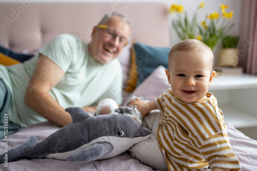 Grandfather and baby bonding with a plush toy photo