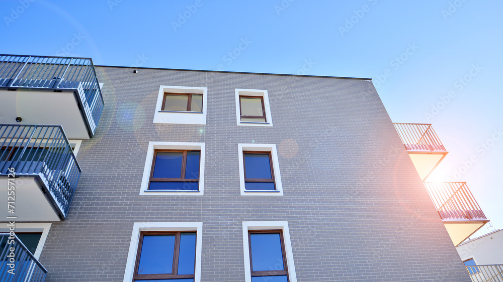 Fototapeta premium Modern apartment building in sunny day. Exterior, residential house facade. Residential area with modern, new and stylish living block of flats. 