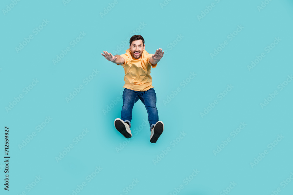 Obraz premium Full body photo of young guy purposeful muscular sportsman in casual clothes jumping doing workout isolated on cyan color background