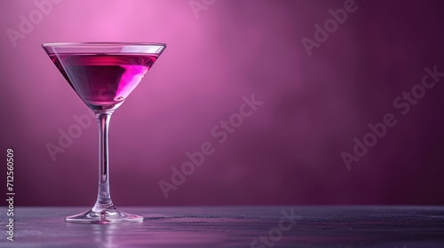  a close up of a wine glass with a liquid inside of it on a table in front of a purple background.
