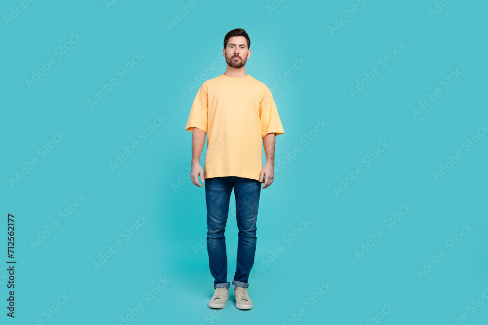Full body photo of guy in yellow t shirt and levis jeans gray sneakers promoting black friday isolated on aquamarine color background Full body photo of guy in yellow t shirt and levis jeans gray sneakers promoting black friday isolated on aquamarine color background
