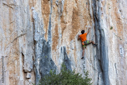 Extreme sport, man, rock climber climbs a difficult route.