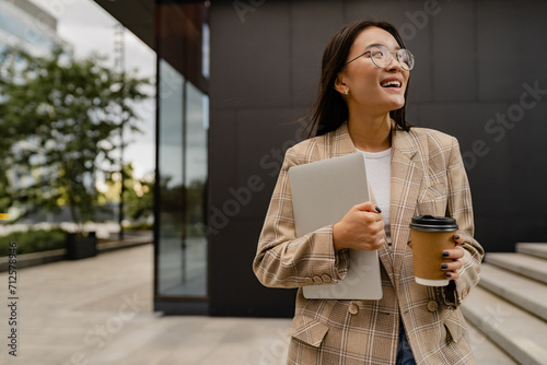 young pretty asian woman walking outside in street doing business