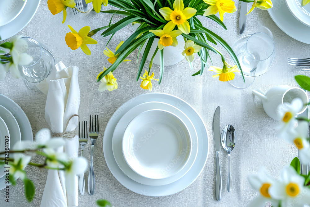 table setting. Plates and cutlery with spring flowers daffodils on a light table - obrazy, fototapety, plakaty 