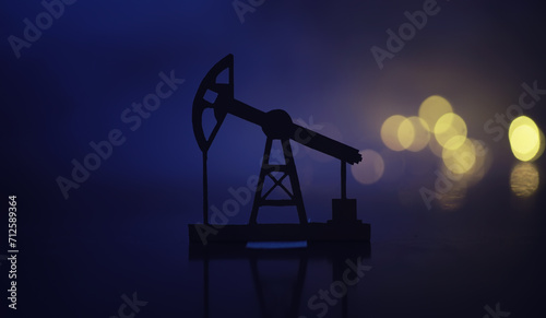 In the evening, the silhouette of oilfield derrick. Beam pumping unit under the night, closeup of photo photo