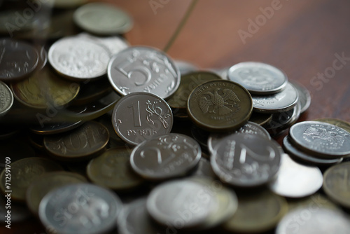 Russian rubles and metal coins inside a glass jar close-up on black blurred background