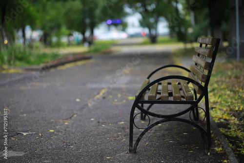 Autumnal park with bench. Falling leaves. Focus on bench