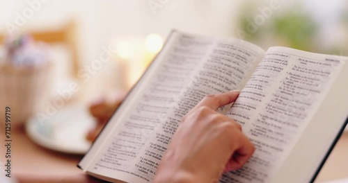 Person, bible book and point with hands, reading or studying for praise, worship or faith in home. Knowledge, closeup and information with religion, learning or spiritual guide for connection to God photo