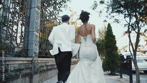 Happy married caucasus couple running and wearing wedding clothes. 