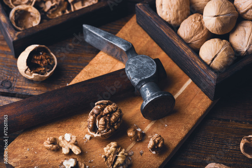 Walnuts and hammer on wooden surface