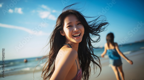 An asian teenage girl happily enjoying herself on a sunny beach during a warm day. girl on the beach in the summer. travelling alone concept, happy moment. 