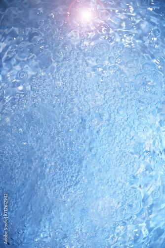 Bubbles and seething water in the light of sunlight.Blue water texture.