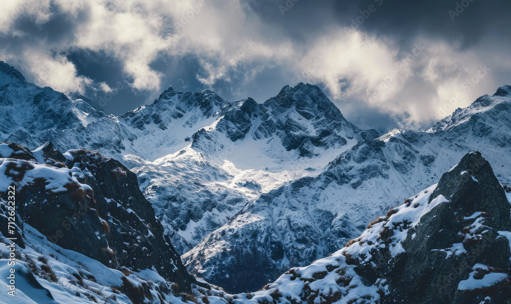 Dramatic snowy peaks under a cloudy sky, bathed in sunlight.