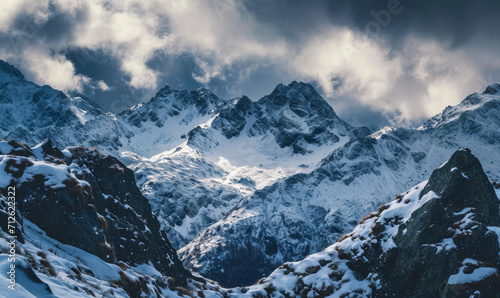 Dramatic snowy peaks under a cloudy sky, bathed in sunlight.