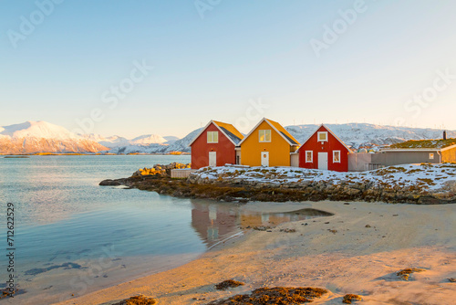 Traditional red and yellow wooden norwegian cabins with ground on the roof. Tromso, Norway © johnkruger1