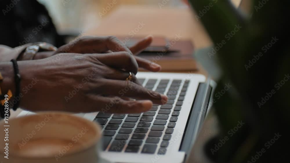 African American man typing text on laptop. Works in the office. Close up. Sitting at the table