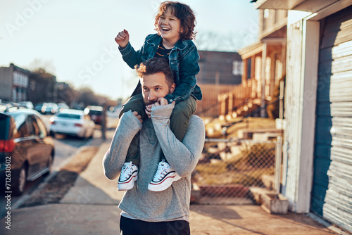 Happy child playing with father in sunny suburban street photo