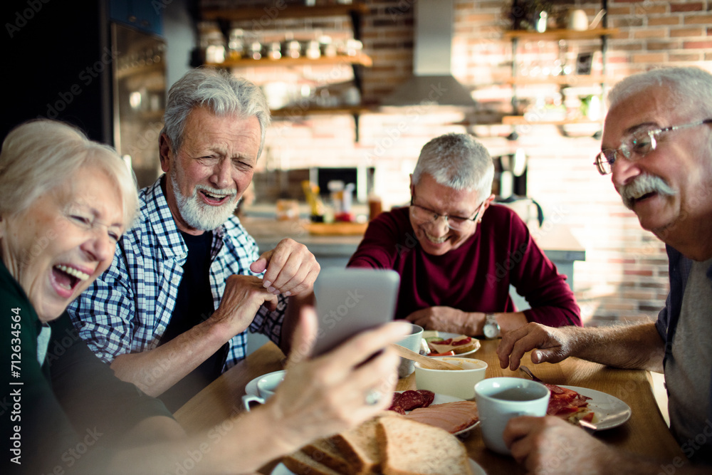 Group of senior friends enjoying conversation and breakfast together Group of senior friends enjoying conversation and breakfast together
