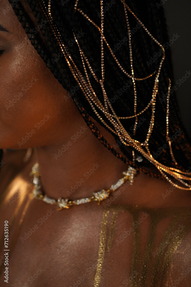 Portrait of an African-American woman with a gold necklace and gold ...