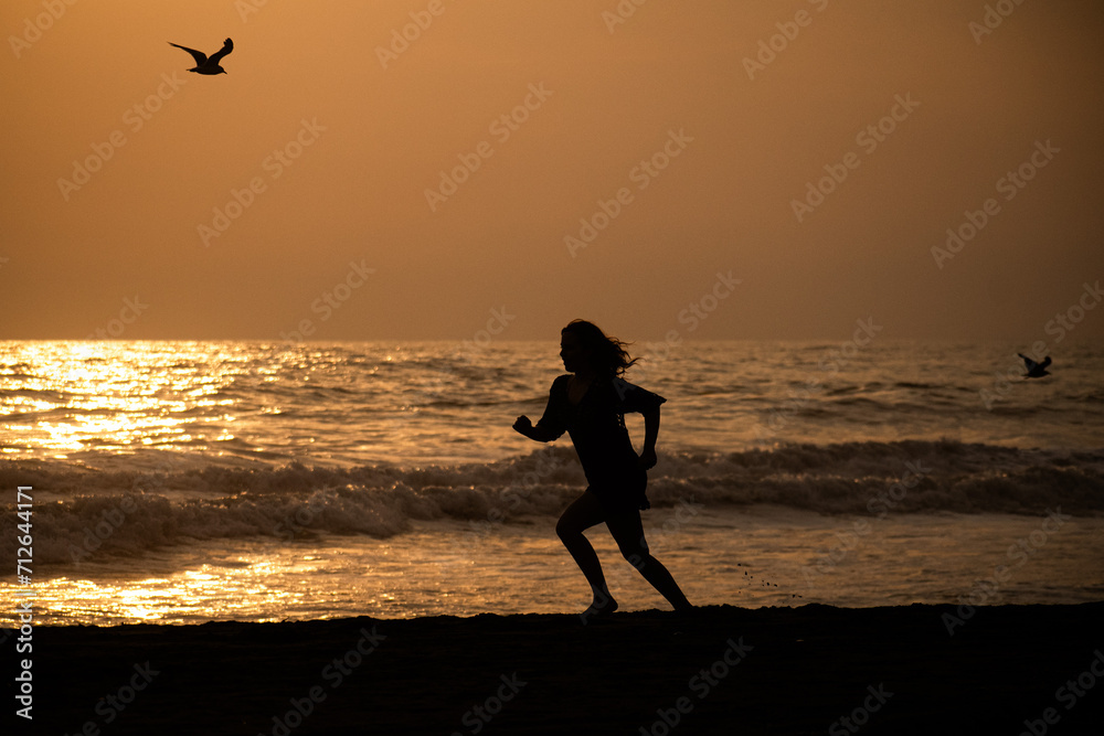 silhouette of a person running on the beach
