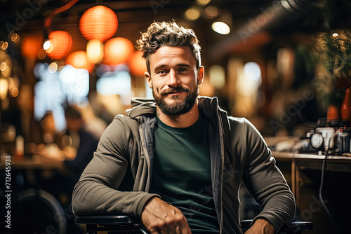 a bearded man in a wheelchair sits comfortably in a bar