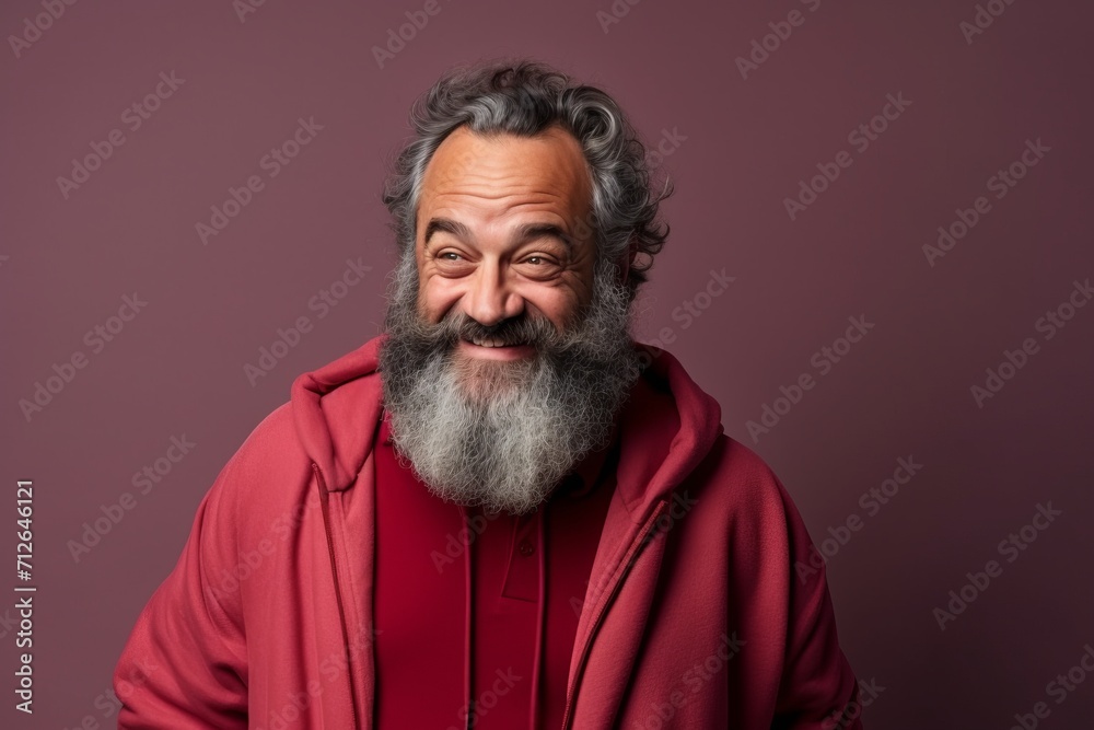 Portrait of a happy senior man with long gray beard and mustache in a red hoodie.